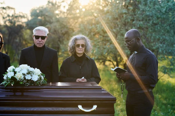Young Pastor Reading Verses Holy Bible While Standing Front Coffin — Stock Photo, Image