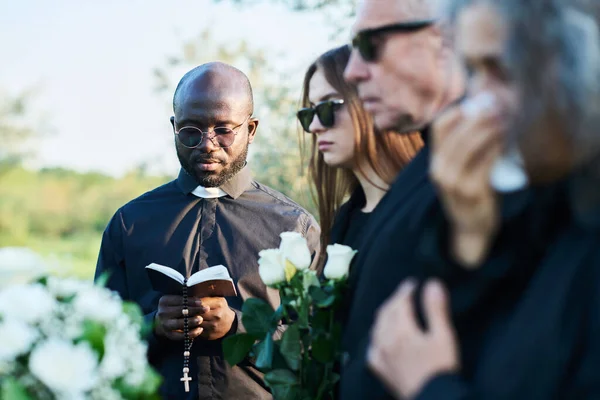 Focus Serious Priest Black Attire Looking Open Holy Bible Funeral — Stock Photo, Image