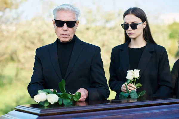 Mature Man His Daughter Sunglasses Mourning Attire Standing Coffin Closed — Stock Photo, Image