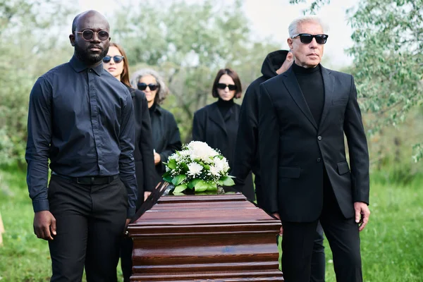 Group Grieving People Mourning Attire Carrying Wooden Coffin Bunch Fresh — Stock Photo, Image