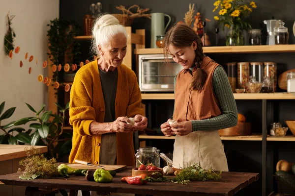Senior Woman Explaining Her Granddaughter How Peel Garlic Pickles While — Stock Photo, Image