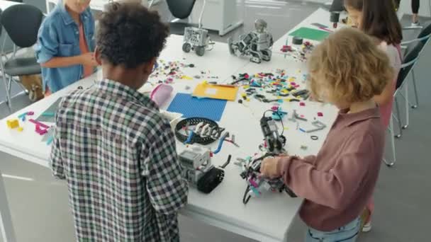 Średni Kąt Ujęcia Młodych Zróżnicowanych Chłopców Konstruujących Elektryczne Modele Robotów — Wideo stockowe