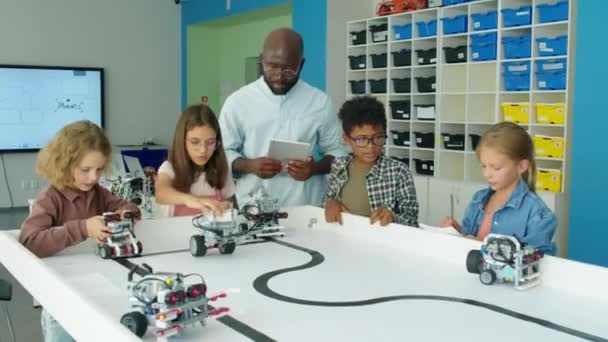 Pełne Ujęcie Nastolatków Wielorasowych Chłopców Dziewcząt Oglądających Elektryczne Modele Robotów — Wideo stockowe