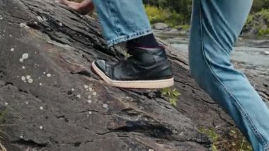 Dağa tırmanan tanınmayan kişinin ayaklarına sığ bir odak noktasıyla çekim.