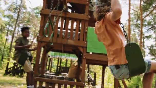 Langzaam Volgen Shot Van Basisschool Kinderen Spelen Schommels Het Park — Stockvideo