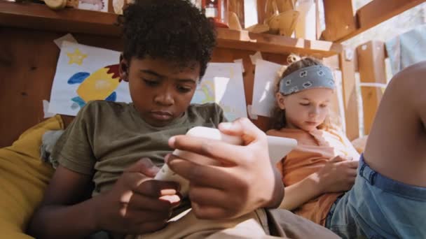 美国黑人和白人小学生白天在树屋玩小玩意的低角度中镜头 — 图库视频影像
