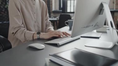 Klavyeye bir şey yazan kadın ofis çalışanının ellerine odaklan.