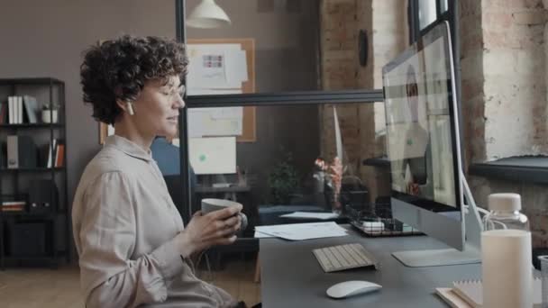 白种人女经理在白天与办公室里的客户进行视频通话时谈论项目的中全景照片 — 图库视频影像