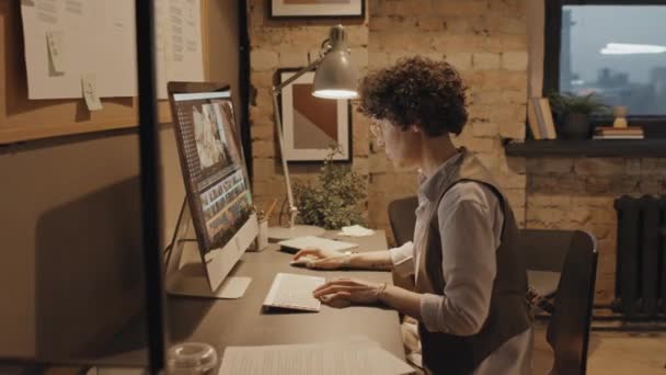 特別なアプリでコンピュータの映像を編集する机に座っている女性のコーカサスオフィスワーカーのドリーズーム — ストック動画