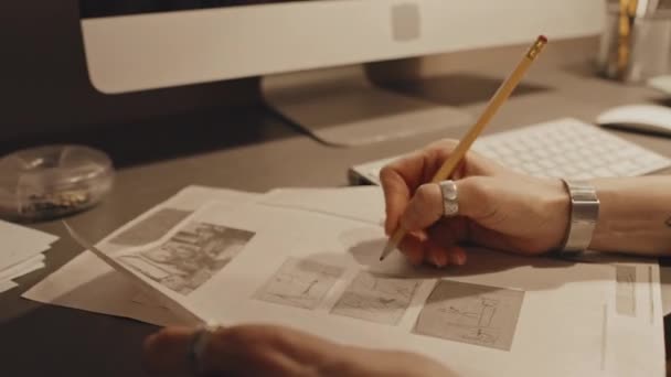 オフィスの机に座っている女性の手に焦点を当て 鉛筆でプロジェクト文書に何かを書く — ストック動画