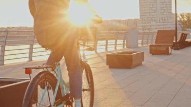 Güneş doğarken bisiklet kaskı takan, şık giyinen, tanınmayan bir kadının fotoğrafını çek.