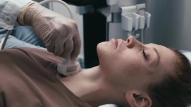 Kadın hasta için ultrason yapan koruyucu eldivenler giyen tanınmayan sonografi uzmanının orta boy yakın çekimi.