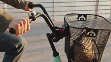 Tanınamayan bir kadının nehir kıyısında bisikletle işe giderken orta boy yakın çekim fotoğrafı.