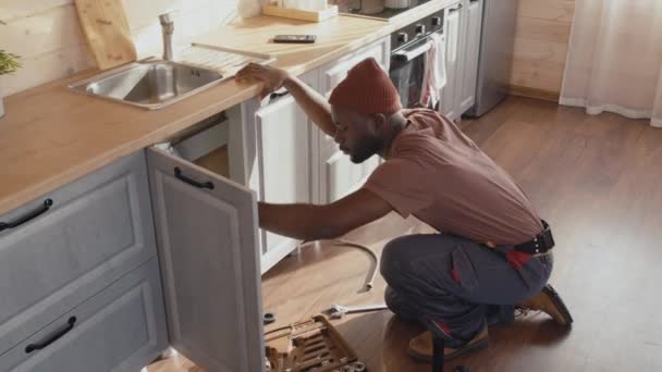 Hoge Hoek Schot Van Afro Amerikaanse Professionele Loodgieter Werken Keuken — Stockvideo
