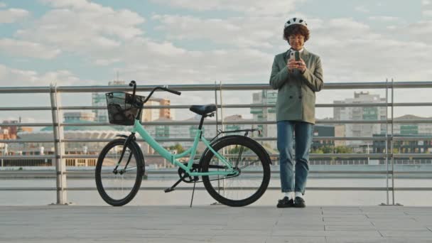 Mulher Caucasiana Moderna Usando Capacete Bicicleta Contra Cerca Margem Mensagem — Vídeo de Stock