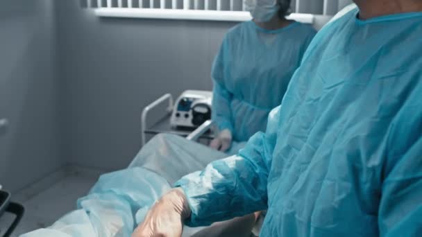 Ameliyathanede Hastalarla Çalışırken Modern Teknolojiyi Kullanarak Kulaklık Takan Profesyonel Cerrahları — Stok video