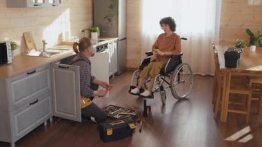Engelli bir kadının profesyonel tesisatçıyla lavabo gideri tamiri hakkında konuşması