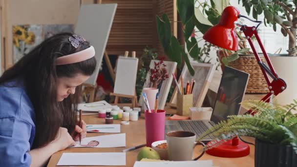 Снимок Современной Девушки Синдромом Дауна Сидящей Столом Дома Рисующей Картину — стоковое видео