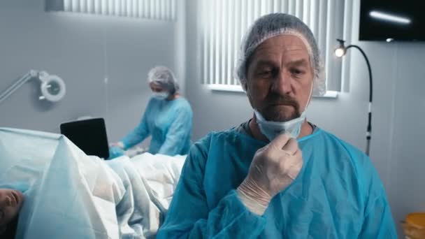 Селективный Портрет Зрелого Хирурга Мужчины Стоящего Операционной Снимающего Маску После — стоковое видео