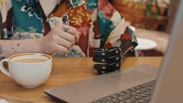 Портативный Снимок Современной Девушки Поколения Протезом Руки Сидящей Столом Кафе — стоковое видео