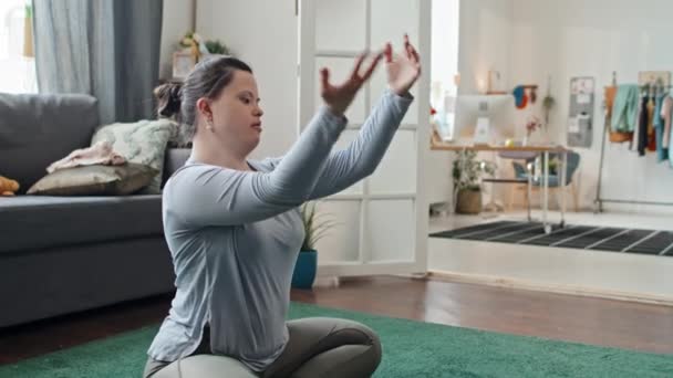 Sendromlu Modern Genç Bir Kadının Oturma Odasında Halıya Oturup Meditasyona — Stok video