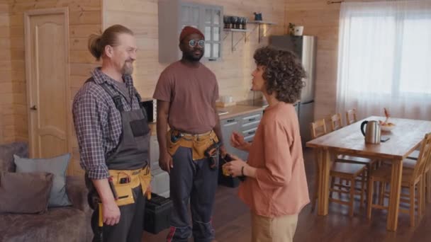 Caucasian Woman Standing Modern Kitchen Thanking Ethnically Diverse Repairmen Work — Stock Video