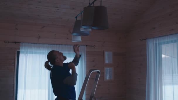 成熟した白人ハンドマンは 彼女のキッチンでランプを変更する障害を持つ女性を助けます — ストック動画