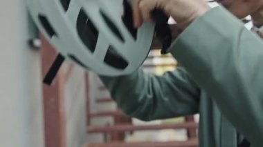 Kafkasyalı, kıvırcık saçlı, gözlüklü, bisiklet kaskı takan modern beyaz kadının seçici odak noktası yavaş çekim.