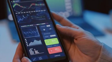 Analitik kripto uygulaması olan akıllı telefonu gece vakti kapalı alanda tutan tanınmayan kişiyi yakın çekim yapın.