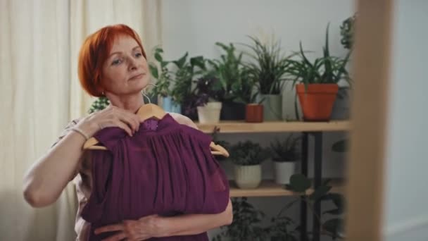 Medium Skott Glad Senior Kvinna Tittar Spegeln Försöker Lila Klänning — Stockvideo