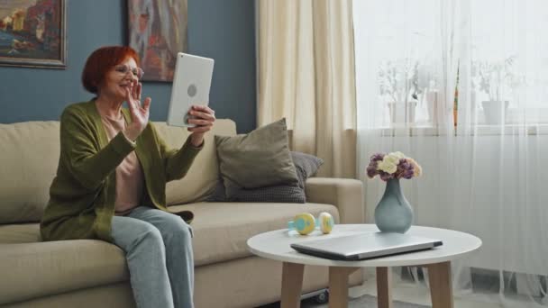 潘宁在客厅里拿着平板电脑 坐在沙发上 与家人进行视频通话 — 图库视频影像