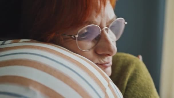 Сосредоточьтесь Расстроенной Пожилой Женщине Рыжими Волосами Очках Обнимающей Неузнаваемого Человека — стоковое видео