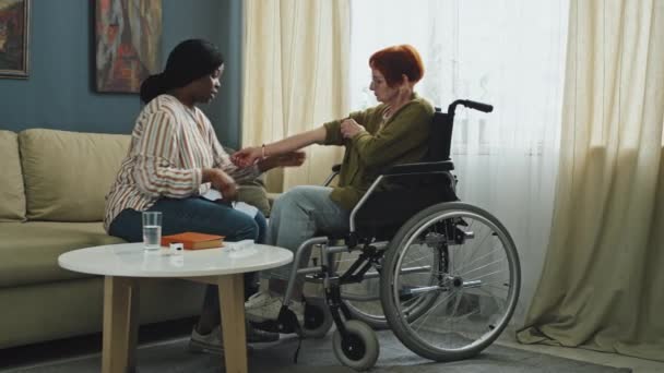 Schwenk Hinterließ Vollbild Einer Seniorin Rollstuhl Und Einer Afroamerikanischen Krankenschwester — Stockvideo