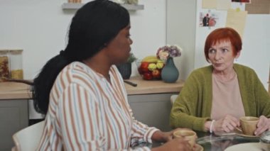 Orta ölçekli, destekleyici Afrikalı Amerikalı bir kadının beyaz bir bayanın yanında oturup zor hayatını anlattığı sahneler.