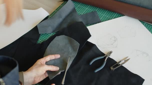 用无法辨认的工匠手拿着一块灰色绒面革 用剪刀剪断部分未来手提包的特写镜头 — 图库视频影像