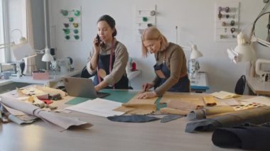 Atölyede çalışan ve özel siparişleri tartışan iki terzinin tam karesi. Bilgisayarlı genç melez kadın cep telefonuyla müşteriyle konuşuyor. Orta yaşlı iş arkadaşı deri parçası ölçüyor.