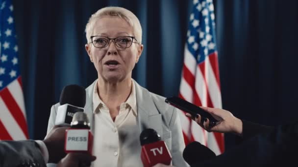 Orta Yaşlı Beyaz Gözlüklü Kadın Basın Sözcüsünün Abd Bayrağı Önünde — Stok video