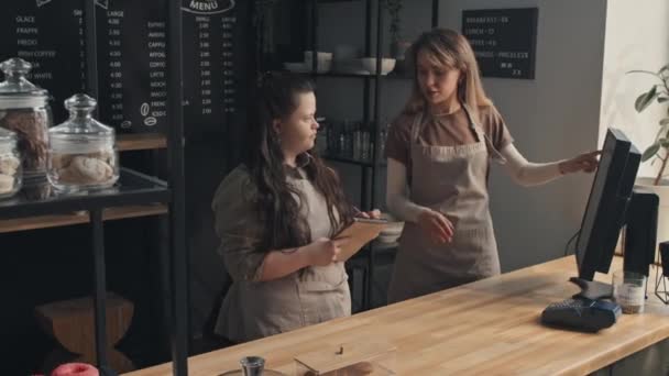 Młoda Kobieta Zespołem Downa Stojąca Przy Ladzie Nowoczesnej Kawiarni Odpowiadająca — Wideo stockowe