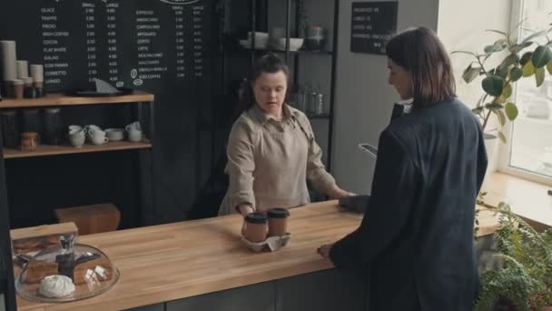 Barista Feminino Com Síndrome Dando Duas Xícaras Café Para Cliente — Vídeo de Stock