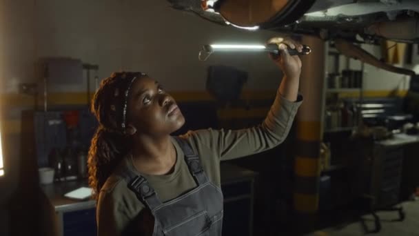 Сучасна Молода Афроамериканська Автомеханіка Тримає Факел Перевіряє Частини Колеса — стокове відео