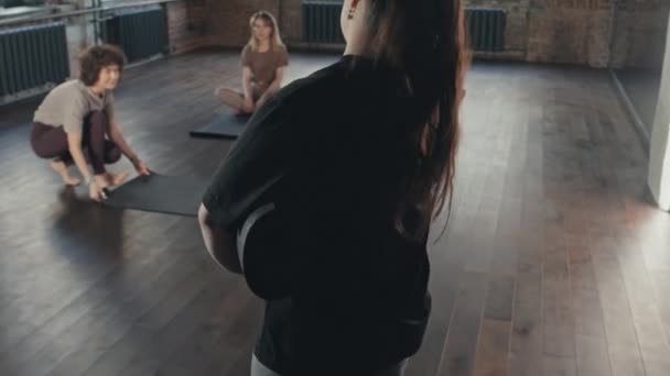 职业瑜伽教练向不明身份的唐氏综合征患者致意的选择性聚焦镜头 — 图库视频影像