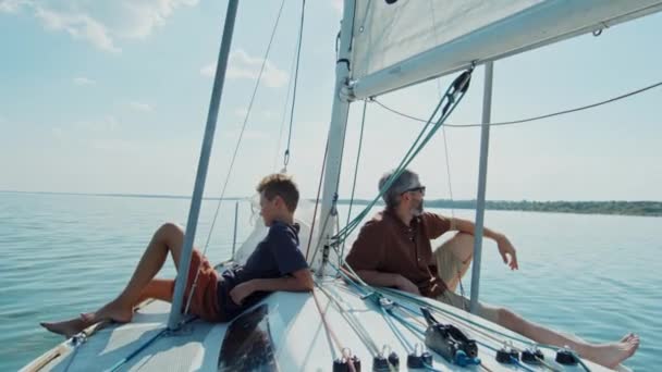 白人男子和他的儿子一起在游艇上度过一个阳光灿烂的夏天 — 图库视频影像