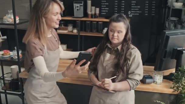 Yüksek Açılı Genç Beyaz Bir Garsonun Sendromlu Meslektaşıyla Akıllı Telefondan — Stok video