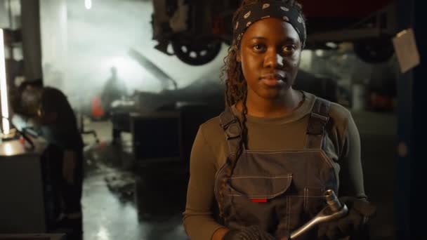 在汽车修理店工作的有信心的年轻非洲裔美国女性汽车技师的选择性聚焦画像 — 图库视频影像