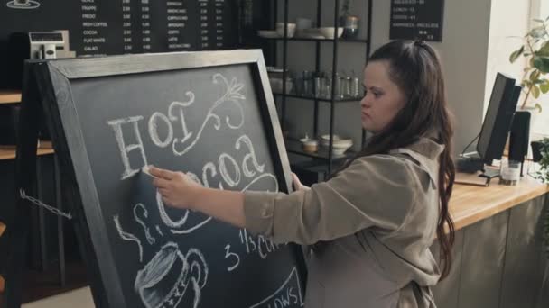 Sendromlu Genç Bir Kadının Modern Kafede Yazı Yazarak Sıcak Kakao — Stok video