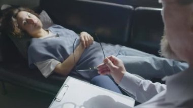 Depresyonlu ya da travma sonrası bozukluğu olan genç bir kadınla çalışan olgun erkek psikoloğunun seçici odak noktası.