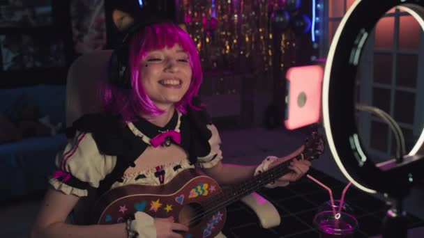 Jonge Vrouwelijke Cosplayer Draagt Roze Pruik Spelen Ukelele Zingen Lied — Stockvideo