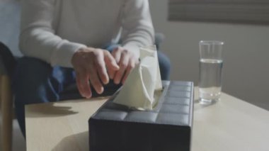 Psikoterapi seansı sırasında kutudan doku alan tanımlanamayan üzgün adamın seçmeli odak noktası.