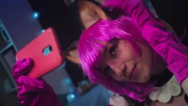 그녀의 친구와 통화를하는 스마트 카메라에 가발과 자동차 귀여운 코스프레 소녀의 — 비디오
