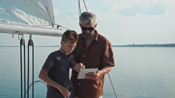 Olgun Beyaz Adam Genç Oğlu Yatta Dikilip Dijital Tablette Harita — Stok video